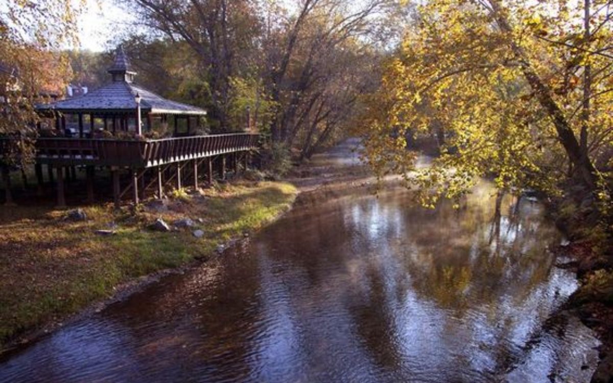 Sun shining on river flowing by gazebo at Loreley Resort in Helen Georgia